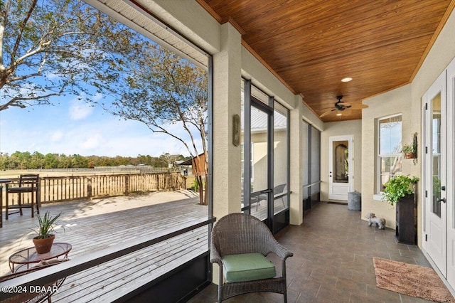 sunroom featuring ceiling fan and wood ceiling