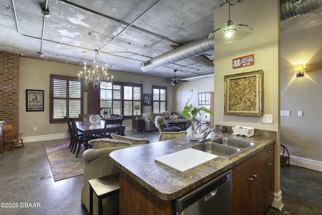 kitchen with concrete flooring, pendant lighting, dishwasher, dark countertops, and a notable chandelier