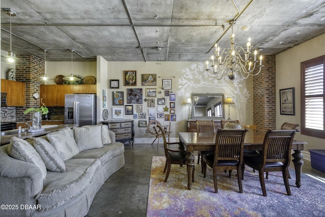 dining area featuring a notable chandelier, finished concrete flooring, and baseboards