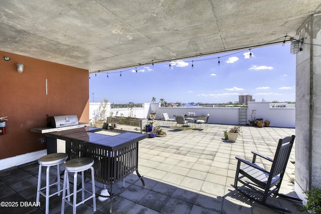 view of patio with outdoor wet bar, area for grilling, outdoor dining space, and fence