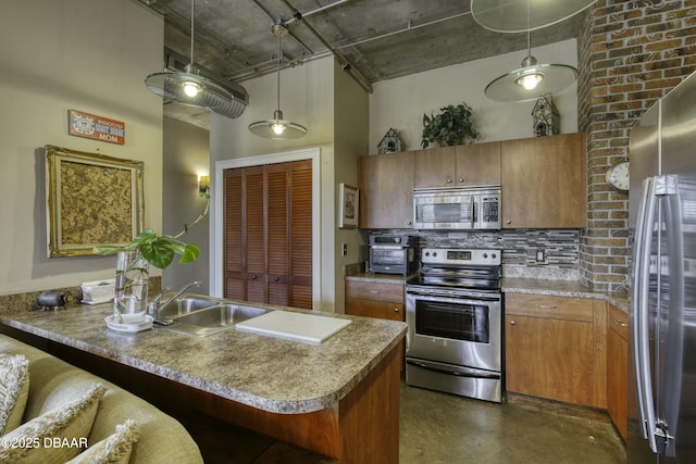 kitchen with a sink, stainless steel appliances, a towering ceiling, brown cabinets, and backsplash