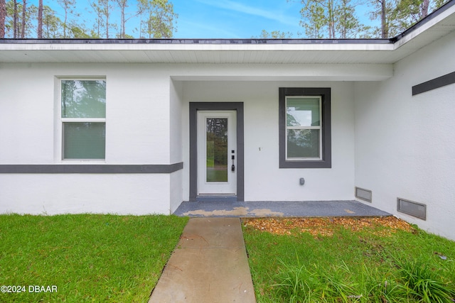 doorway to property with a yard