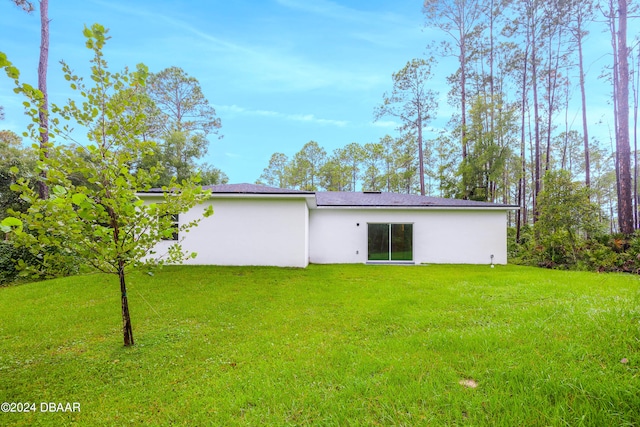 back of house featuring a lawn