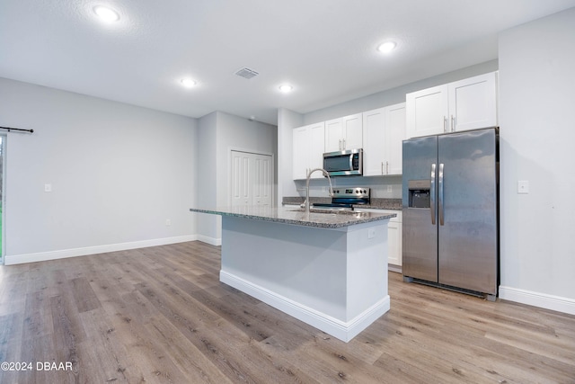 kitchen featuring white cabinetry, appliances with stainless steel finishes, a center island with sink, and sink