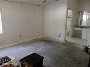 empty room with concrete flooring, ceiling fan, and a healthy amount of sunlight