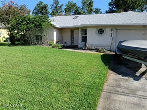 ranch-style home featuring a garage and a front yard