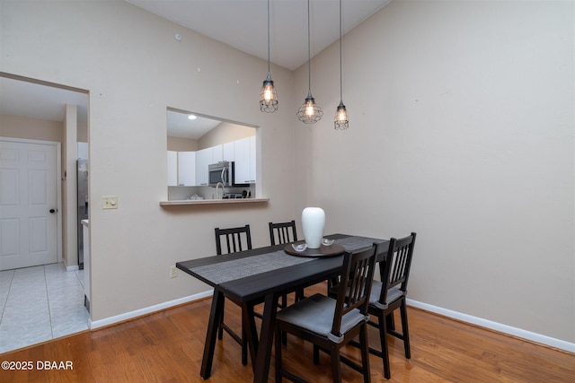 18 Landings Ln, Ormond Beach, FL 32174 - dining space with baseboards, wood finished floors, and high vaulted ceiling