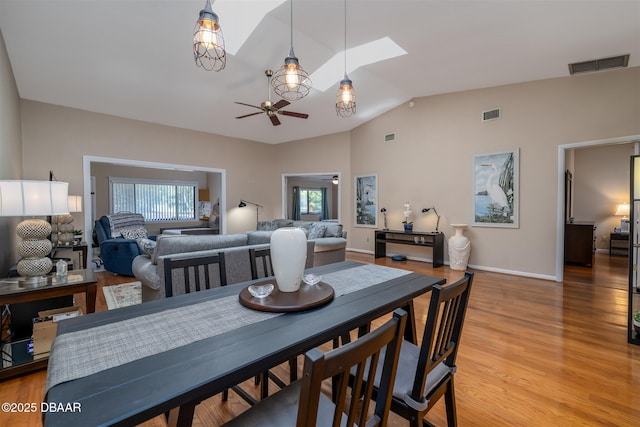 18 Landings Ln, Ormond Beach, FL 32174 - dining room with a ceiling fan, vaulted ceiling, light wood finished floors, a skylight, and baseboards
