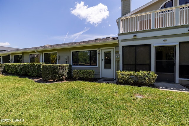 18 Landings Ln, Ormond Beach, FL 32174 - property entrance with a balcony, a lawn, and a chimney