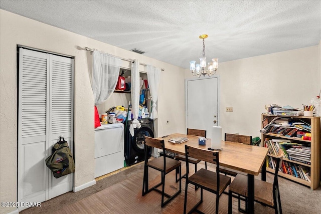 carpeted dining area featuring a textured ceiling, washer / clothes dryer, visible vents, and a notable chandelier