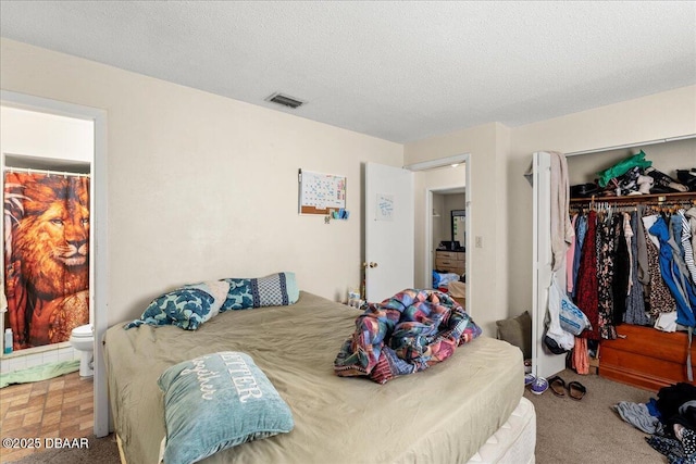 carpeted bedroom with a closet, visible vents, and a textured ceiling