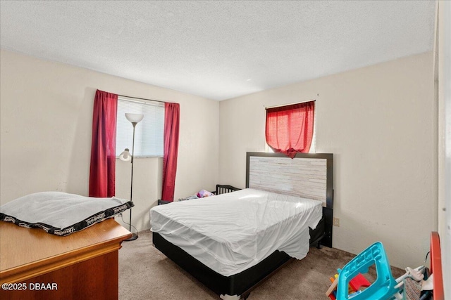 bedroom with carpet floors, multiple windows, and a textured ceiling