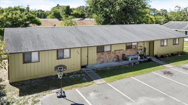 view of front of home with uncovered parking and a shingled roof