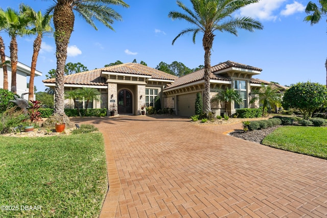 mediterranean / spanish home with a garage and a front yard