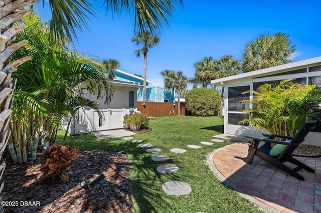 view of yard featuring a gate, a sunroom, and fence