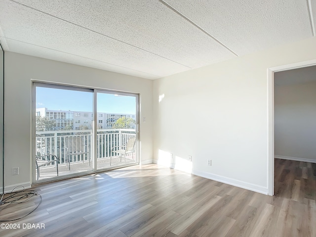 empty room with hardwood / wood-style flooring and a textured ceiling