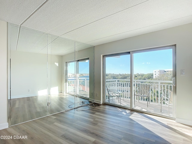 empty room with a textured ceiling and hardwood / wood-style flooring