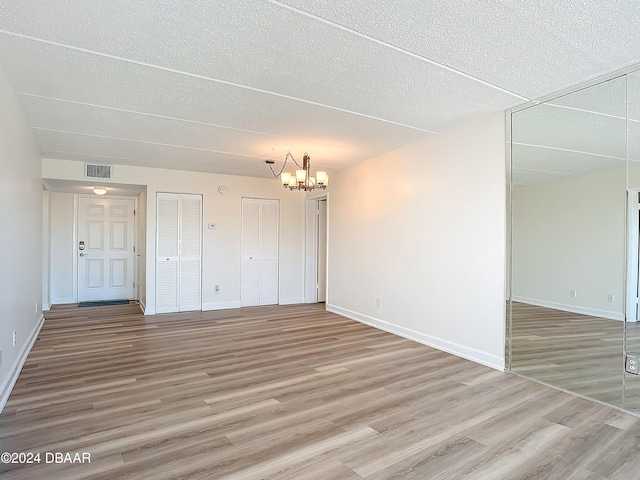 interior space featuring hardwood / wood-style floors, a textured ceiling, and a chandelier