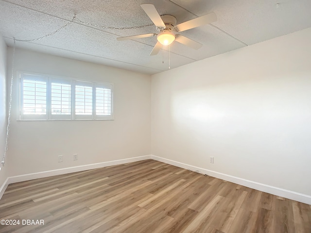 spare room with hardwood / wood-style floors and ceiling fan