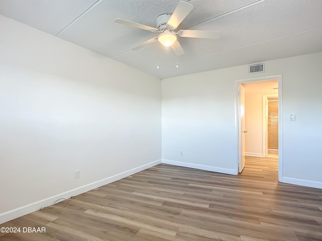 spare room featuring ceiling fan, a textured ceiling, and hardwood / wood-style flooring