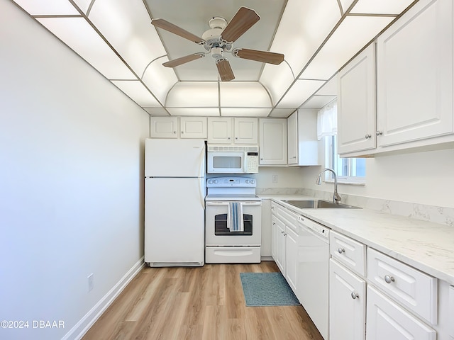 kitchen with light wood-type flooring, light stone counters, white appliances, sink, and white cabinetry