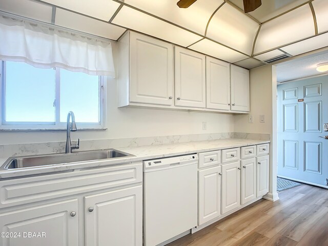 kitchen featuring sink, light stone counters, white dishwasher, light hardwood / wood-style floors, and white cabinets