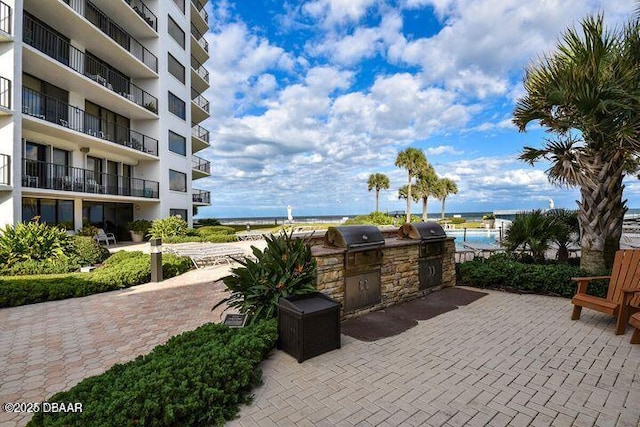 view of patio / terrace with a grill, area for grilling, and a water view