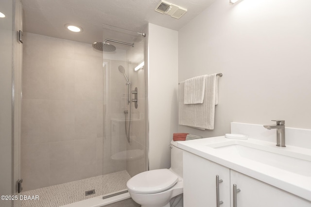 bathroom featuring vanity, toilet, and a shower with shower door