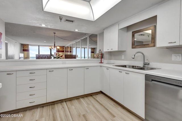 kitchen with white cabinets, dishwasher, sink, and a wealth of natural light