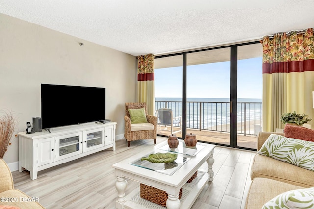 living room with expansive windows, a textured ceiling, and light hardwood / wood-style flooring