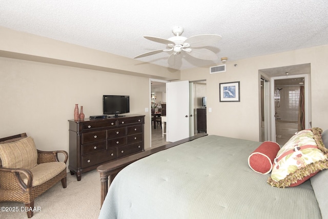 carpeted bedroom with a closet, a textured ceiling, ensuite bathroom, and ceiling fan