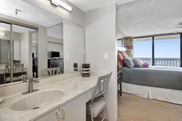 bathroom with vanity, a wall of windows, and a textured ceiling