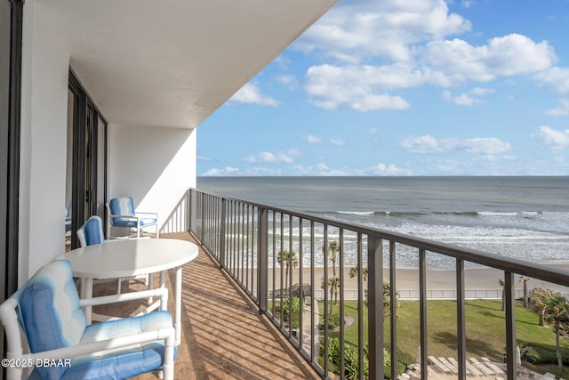 balcony featuring a water view and a beach view