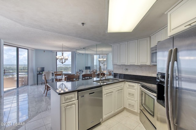 3023 S Atlantic Ave Unit 7070, Daytona Beach, FL 32118 - kitchen featuring stainless steel appliances, a chandelier, a peninsula, a sink, and decorative backsplash