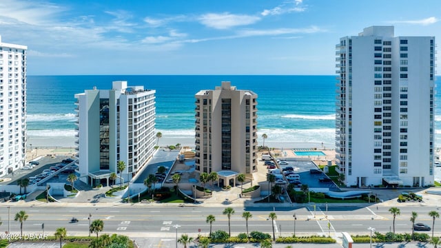 birds eye view of property with a water view and a beach view