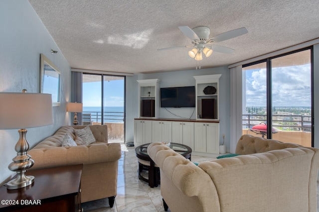 3023 S Atlantic Ave Unit 7070, Daytona Beach, FL 32118 - living room featuring a wall of windows, a textured ceiling, light marble finish floors, and ceiling fan