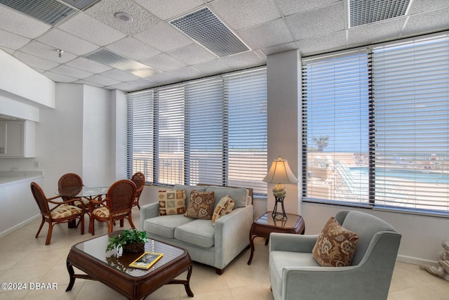 tiled living room featuring a paneled ceiling