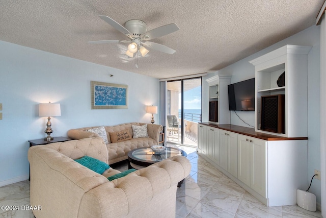 living room featuring ceiling fan, floor to ceiling windows, and a textured ceiling