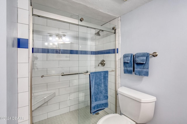 bathroom featuring toilet and a shower with door