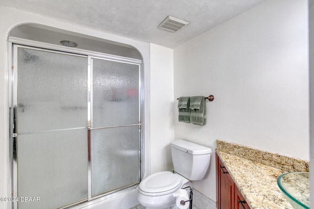 bathroom featuring vanity, toilet, and a shower with shower door