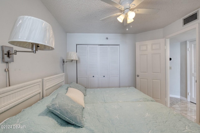 bedroom with a textured ceiling, a closet, and ceiling fan