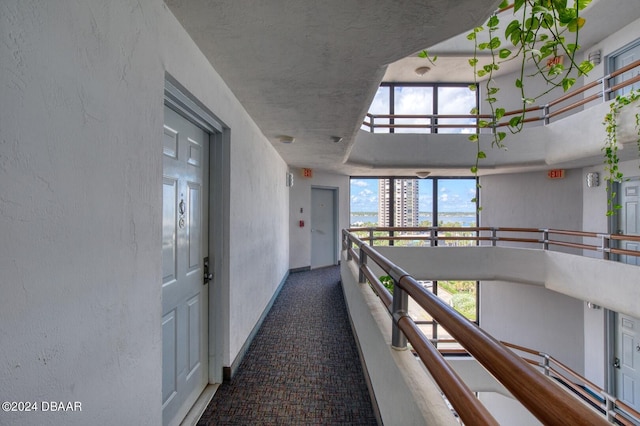 3023 S Atlantic Ave Unit 7070, Daytona Beach, FL 32118 - hall with carpet flooring, a textured wall, baseboards, and an upstairs landing