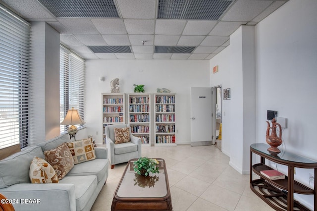 tiled living room featuring a drop ceiling