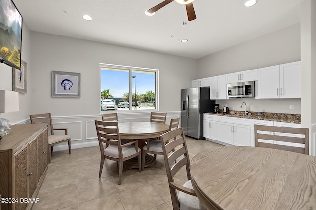 tiled dining area featuring ceiling fan and sink