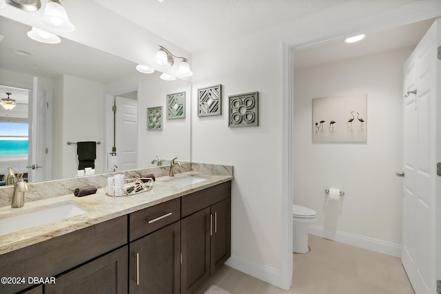 bathroom with tile patterned floors, vanity, a textured ceiling, and toilet