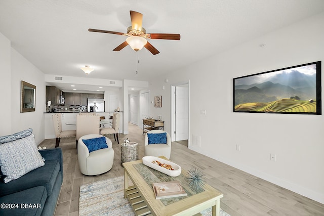 living room featuring ceiling fan and light hardwood / wood-style flooring