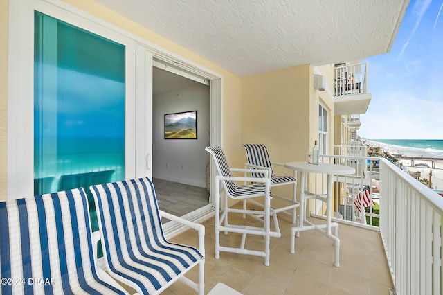 balcony with a water view and a beach view