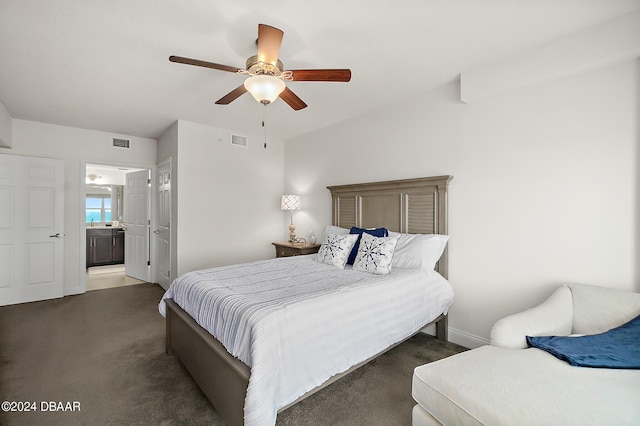 bedroom featuring ensuite bath, ceiling fan, and dark colored carpet