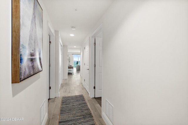 hallway with light hardwood / wood-style floors