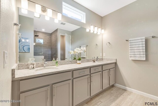 bathroom featuring a tile shower, vanity, and hardwood / wood-style flooring